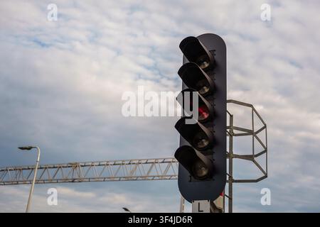 Feu de signalisation ferroviaire vertical montrant une indication rouge contre un ciel bleu nuageux, représentant la sécurité des transports et le contrôle des voies, la sécurité des trains Banque D'Images