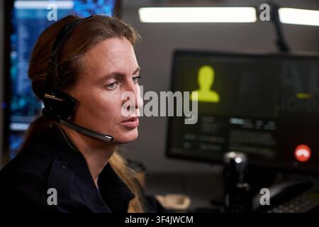 Dispatcheuse traitant la communication d'urgence au bureau Banque D'Images