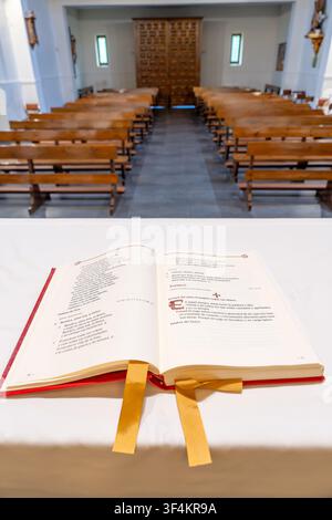Missel ouvert reposant sur l'autel avec des bancs d'église en arrière-plan, symbolisant la foi et le culte Banque D'Images