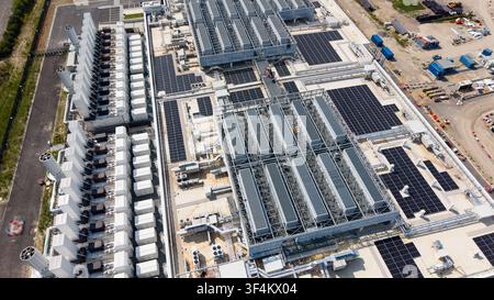Vue aérienne d'un grand centre de données hyperscale présentant des rangées d'unités de refroidissement, des panneaux solaires sur le toit et une infrastructure industrielle à Set Banque D'Images