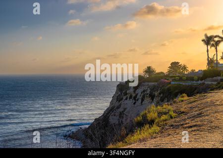 Vue sur l'océan Pacifique depuis le sommet d'une falaise où les jardins et les arrière-cours bordent un sentier public qui suit les lignes courbes des falaises. Banque D'Images