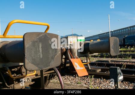 Vue rapprochée des tampons en acier lourds et du système d'attelage sur un wagon de marchandises garé dans une cour de triage. Concept de technologie ferroviaire Banque D'Images