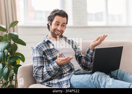 Homme caucasien souriant travaillant sur un ordinateur portable, se détendant à la maison, concept d'affaires Banque D'Images
