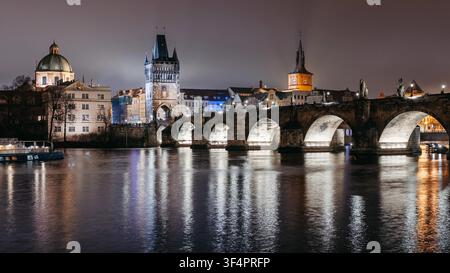 Timelapse. Pont Charles la nuit en hiver vu de Lesser Town Riverbank. Rivière Vltava, touristes marchant photo de haute qualité Banque D'Images