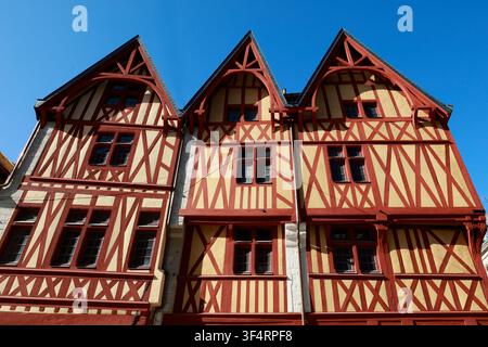 Façades de maisons à colombages avec des poutres rouges et un remplissage jaune. Banque D'Images