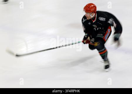 Un joueur de hockey sur glace patine rapidement sur la glace. Banque D'Images