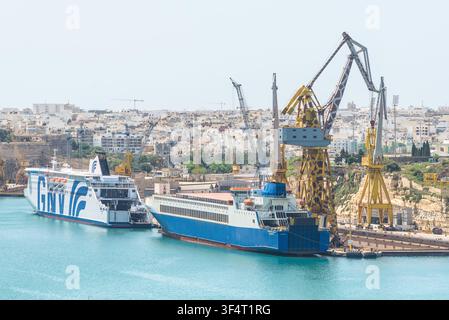 Valletta, Malte – 20 mai 2025 : Vue sur les navires commerciaux amarrés dans le port de La Valette, avec une vedette GNV à passagers accompagnée du véhicule Eurocargo Malta Banque D'Images
