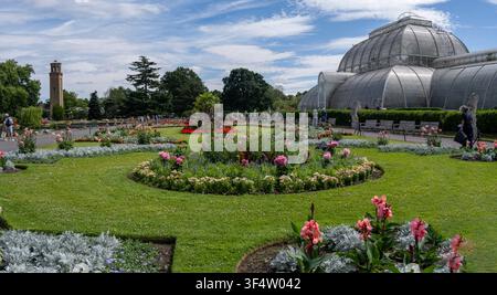 Vue large de la Serre tropicale et des parterres de fleurs formels des Royal Botanic Gardens, Kew, Londres, Angleterre par une journée d'été ensoleillée. Banque D'Images
