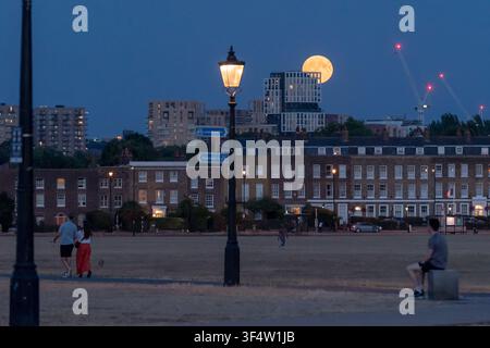 Londres, Royaume-Uni. 29 juillet 2026. Météo du Royaume-Uni : Une pleine lune Buck se lève sur Blackheath dans le sud-est de Londres. Appelée "Buck Moon", en référence au moment où les bois des cerfs mâles poussent, la pleine lune de juillet est depuis longtemps associée à la détente et à l'observation des cycles de la nature. Crédit : Guy Corbishley/Alamy Live News Banque D'Images