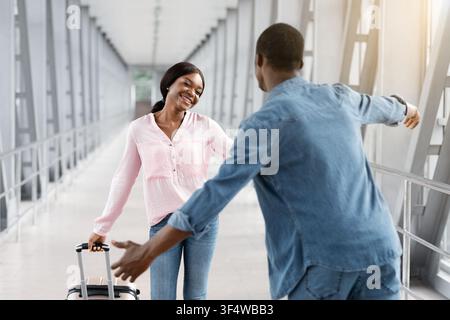 Bonne rencontre de femme afro-américaine avec Boyfriend dans le terminal de l'aéroport Après l'arrivée Banque D'Images