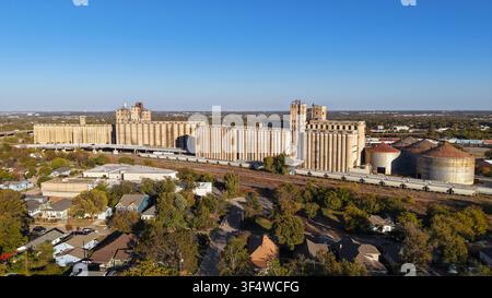 Vue aérienne des silos à grains historiques et des silos industriels entourés de voies ferrées et de maisons résidentielles à Fort Worth, Texas, États-Unis Banque D'Images