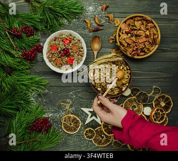 Le repas traditionnel slave de fête kutia est présenté dans un bol en bois accompagné de maïs, de noix et de baies sur un fond sombre à la lumière des bougies. Banque D'Images