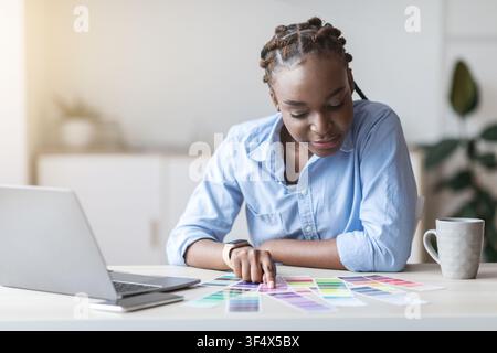 Jeune Afro-féminine Interior Designer vérifier les nuances de couleurs pour le nouveau Projet Banque D'Images