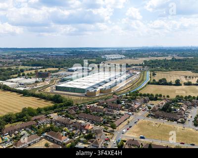 Vue aérienne d'un grand centre de données entouré de logements de banlieue, de champs verts et d'un canal au Royaume-Uni. Banque D'Images