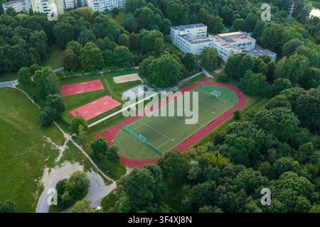 Vue aérienne d'un complexe sportif avec un terrain de football, une piste d'athlétisme et des terrains de basket entourés d'arbres verts luxuriants à Vilnius, comté de Vilnius, L Banque D'Images