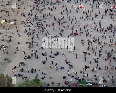 Vue aérienne de la plage de Mertasari bondée de gens faisant voler des cerfs-volants sur le rivage sablonneux à Denpasar Selatan, Bali, Indonésie. Banque D'Images