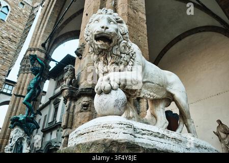 Florence, Italie - Mai 2026 : Statue en marbre du Lion Medici et sculpture de Persée portant la tête de Méduse à la Loggia dei Lanzi Banque D'Images