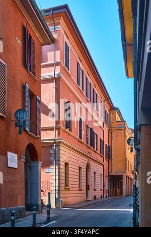 Bologne, Italie - Mai 2026 : Rue historique avec des bâtiments résidentiels colorés en saumon et des volets en bois Banque D'Images