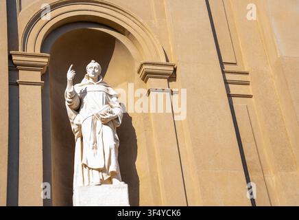 Bergamo, Italie – 16 juin 2026 : Statue classique en pierre blanche placée dans une niche murale sur la façade d'une église historique à Bergamo, Italie. Architecture détaillée Banque D'Images