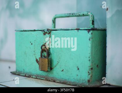 Macro prise d'une boîte métallique verte vintage sécurisée avec un cadenas rouillé Banque D'Images