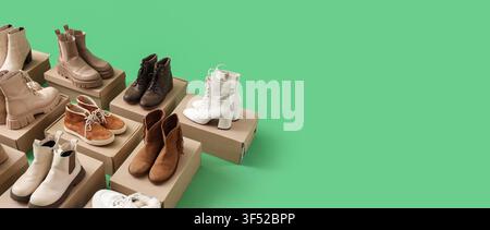 Diverses paires de bottes et chaussures élégantes pour femmes sur des cartons, collection de chaussures et de mode sur fond vert Banque D'Images