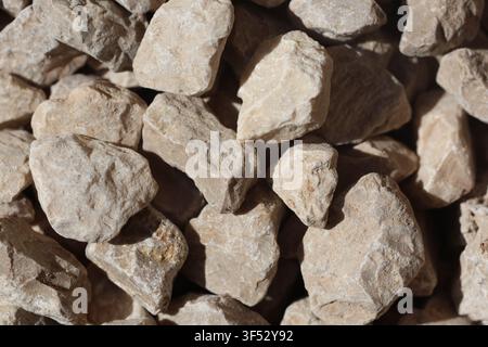 Texture en plein cadre de gravier de calcaire concassé et de pierres angulaires. Surface rugueuse en pierre concassée beige pour la construction et l'aménagement paysager Banque D'Images