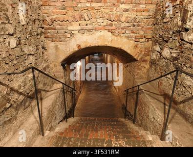 Anciens escaliers en pierre et en brique menant à un long et étroit passage de tunnel d'une forteresse médiévale Banque D'Images
