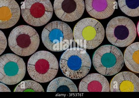 Motif abstrait vibrant de crayons de couleur taillés en rond. Gros plan d'une texture en bois et de mines de graphite multicolores remplissant toute la surface de l'image. Banque D'Images