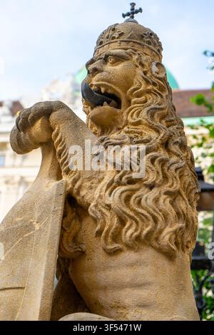 Statue de lion couronné de pierre avec bouclier près du bâtiment du palais impérial de Hofburg à Vienne, Autriche. Banque D'Images