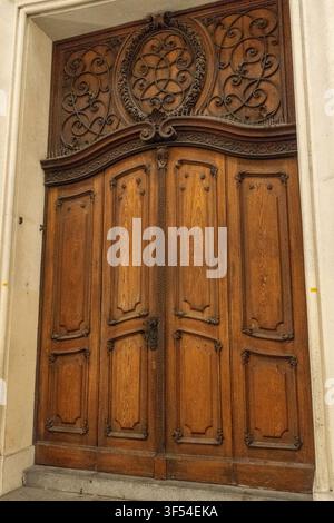 Porte en bois ornée avec panneau transalpine sculpté à l'entrée d'un bâtiment historique à Vienne, Autriche. Banque D'Images