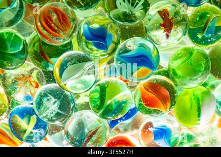 Des billes en verre clair colorées montrant des motifs et des designs abstraits Banque D'Images