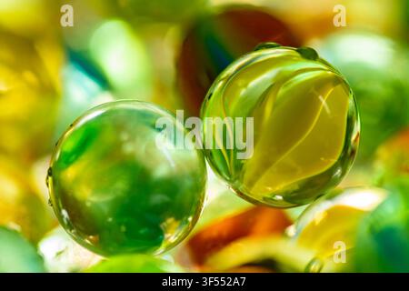 Des billes en verre vert et jaune montrant des réflexions et des motifs Banque D'Images