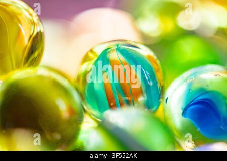 Gros plan de billes en verre brillantes montrant des couleurs vives, des reflets et un flou artistique doux Banque D'Images