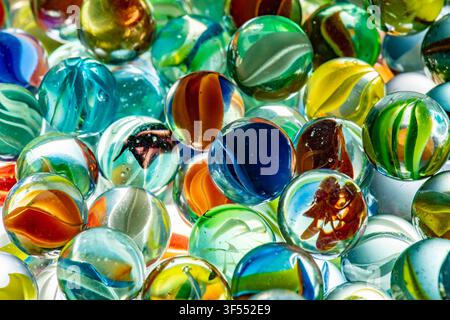 De nombreuses billes en verre colorées affichant des motifs et des reflets complexes Banque D'Images
