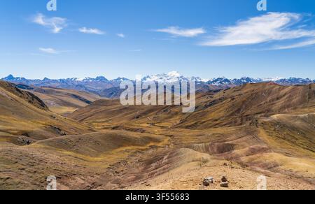 Plan panoramique du sommet enneigé d'Ausangate visible au loin à travers les vallées de la région de la Montagne Arc-en-Ciel de Palccoyo, au Pérou Banque D'Images