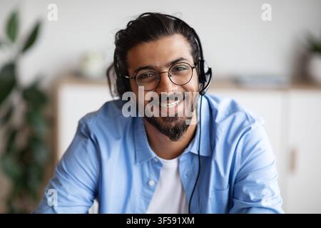 Opérateur du centre d'appels. Gros plan d'un homme indien souriant dans un casque Banque D'Images