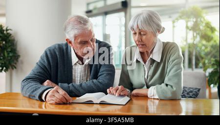 Lecture, bible et couple de personnes âgées à la maison avec foi, bien-être spirituel ou religion dans le mariage. Culte, retraite et homme et femme âgés avec Banque D'Images
