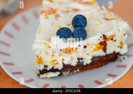 Morceau de cheesecake au caillé garni de myrtilles fraîches dans une assiette à Coesfeld, Allemagne Banque D'Images