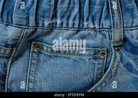 Tissu en jean bleu montrant la texture, la poche, les coutures et les rivets métalliques Banque D'Images