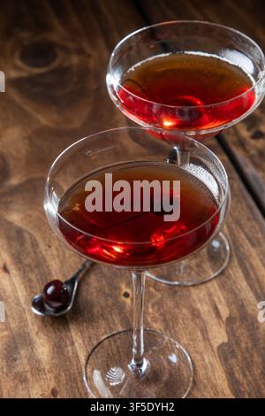 Deux Manhattan au whisky servis avec une cerise sur un fond en bois rustique Banque D'Images