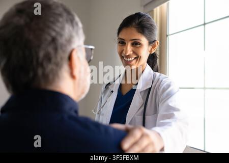Médecine sud-asiatique souriante consultant un patient dans une clinique Banque D'Images