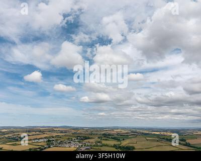 Une vue aérienne étendue met en valeur le patchwork de champs agricoles verdoyants et dorés entourant le village de Lanreath dans les Cornouailles, en Angleterre. Banque D'Images