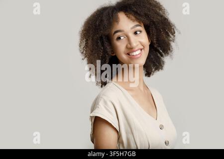 Beau modèle, étudiant, blogueur ou employé. Bonne jeune femme afro-américaine aux cheveux bouclés Banque D'Images