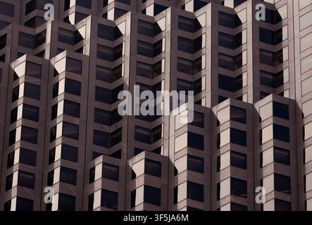 Vue abstraite d'une façade moderne de gratte-ciel à San Francisco, présentant des fenêtres géométriques répétitives et des ombres nettes, idéale pour l'architecture, le design, Banque D'Images