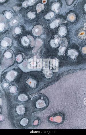 Gros plan aérien des textures de croûte de sel et des formations minérales circulaires sur le lac salé sec de Laguna Espejo, créant un motif naturel abstrait dans des tons doux Banque D'Images