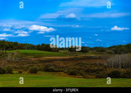 Une vue panoramique étendue sur les pâturages verts ondulants et les collines boisées de la vallée de la Gatineau sous un ciel nuageux Banque D'Images