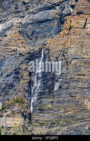Parc national des Glaciers au Montana. Une petite cascade dévalant une falaise rocheuse vue depuis la route Going-to-the-Sun Banque D'Images
