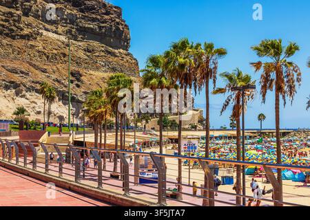 Belle vue de la promenade d'Amadores Beach avec des palmiers et des falaises rocheuses en arrière-plan. Gran Canaria. Espagne. Banque D'Images