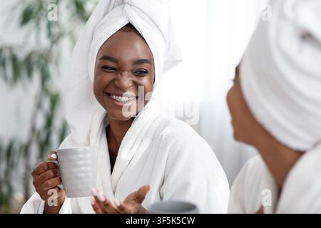 Deux jeunes femmes africaines plaisantant en buvant du thé Banque D'Images