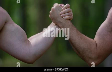 Les mains en force. Rivalité, gros plan sur la lutte au bras masculin. Hommes mesurant les forces, les bras. Deux hommes luttent au bras. Rivalité, vs, défi, force Banque D'Images